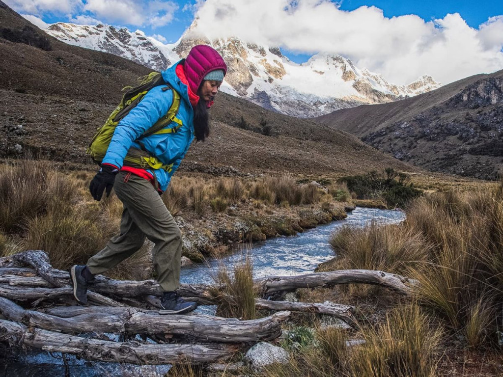 Excursionista bien equipada realizando una caminata a gran altitud, representativo de los paisajes de Cusco y Puno - Avalos Tours