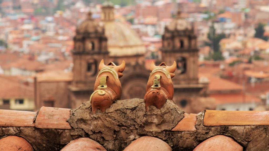 Pareja de Toritos de Pucará en un techo con vistas a Cusco, mostrando el amuleto que explica "qué significa torito de pucara"- Avalos Tours.