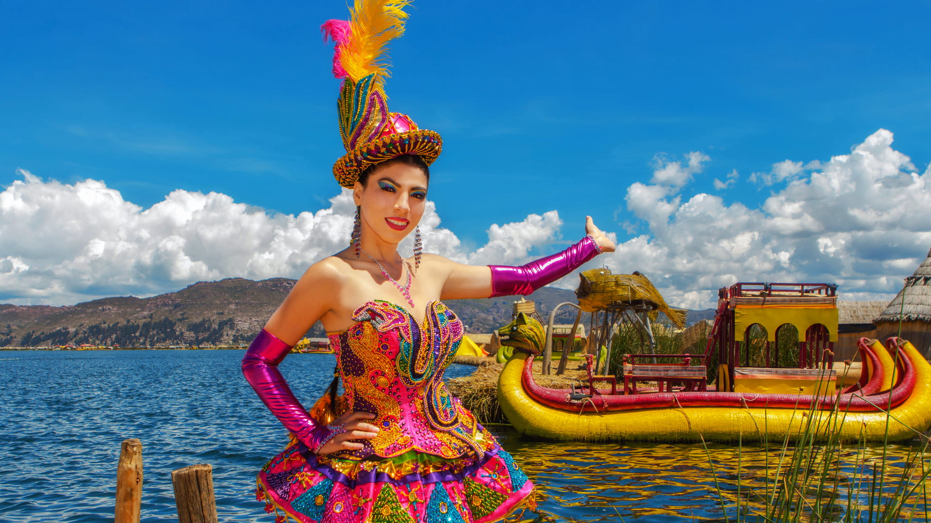 Blog de viajes 9 Danzante con traje colorido y plumas posando frente a una balsa de totora y el Lago Titicaca. La belleza de las danzas de la fiesta de Puno.
