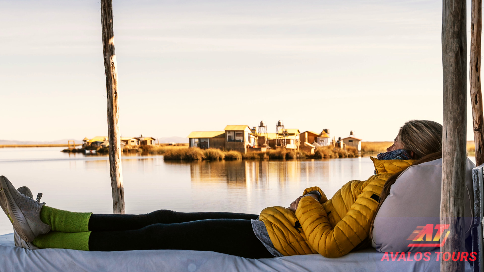 Blog de viajes 8 Viajera recostada en una cama de descanso en las Islas Uros, usando chaqueta abrigadora y gorro. El descanso es clave para protegerse del sol lago Titicaca.
